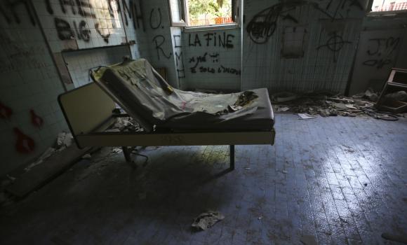letto distrutto in un locale abbandonato