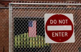 Immigrazione temporaneamente sospesa negli USA: nella foto un cartello con la scritta Do not enter con dietro la bandiera USA.