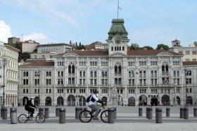 Ciclisti transitano davanti il Palazzo del Municipio a Trieste.