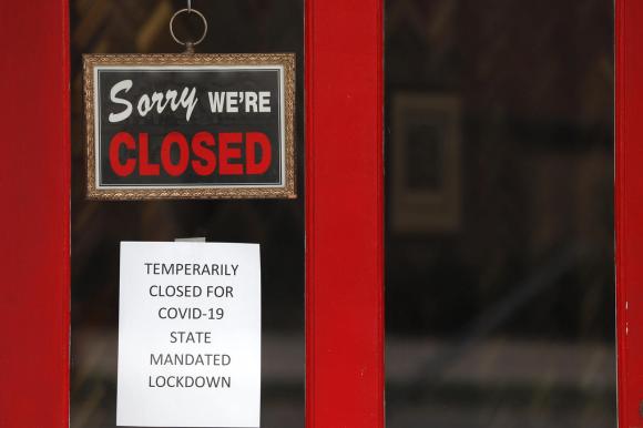 Un cartello esposto alla porta di un commercio con scritto Sorry we re closed.