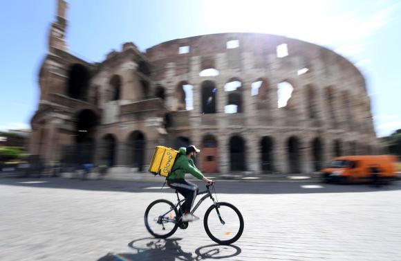 Una due ruote sfreccia davanti al Colosseo.