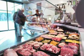Una macelleria con in vista il bancone pieno di diversi tipi di carne.