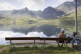 Perona seduta davanti a lago alpino