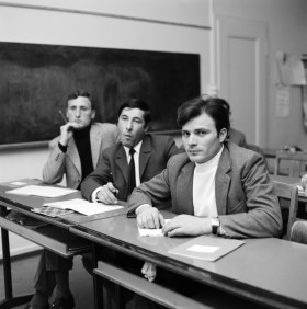 tre persone sedute in una classe