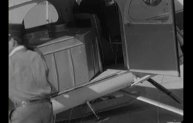 Lato di un aereo con portellone aperto e una grossa tanica all interno; si intravvede uomo in uniforme