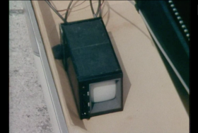 Immagine di un vecchio monitor video (cassa lunga e schermo piccolo) su quello che appare come un tappetino.