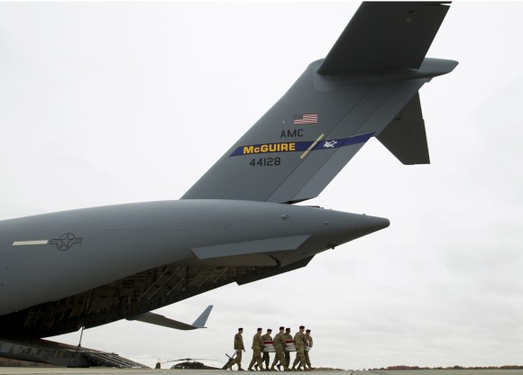 Militari trasportano una bara fuori da un aereo