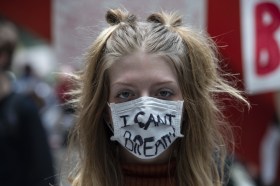 una manifestante che indossa una mascherina protettiva