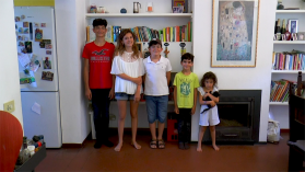 Due bambine e tre bambine di età diverse messi in rango per statura in un soggiorno con libri