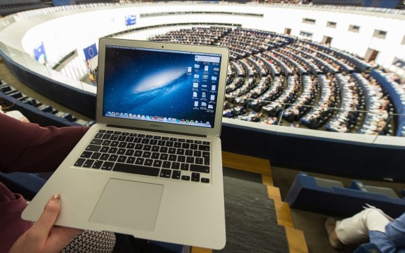 Primo piano di un MacBook Air sulle ginocchia di una persona seduta tra il pubblico nel Parlamento europeo di Strasb