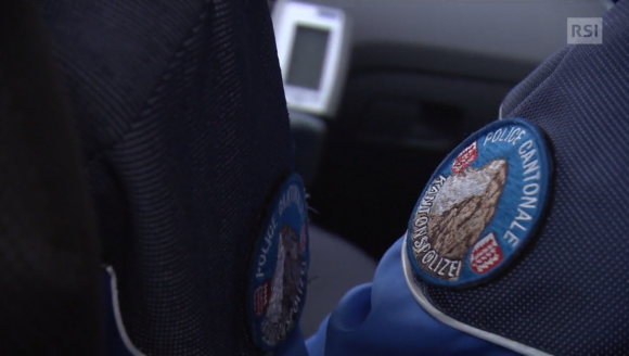 Badge militare con scritta Police Valais sulla manica di uniforme di agente in automobile