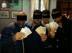 Quattro dei carabinieri fermati che esibiscono i proventi della loro attività criminosa