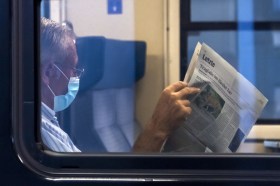 Lettore di un quotidiano svizzero su un treno