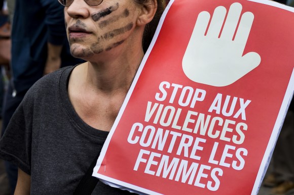 Donna con cartello con la scritta stop alla violenza contro le donne