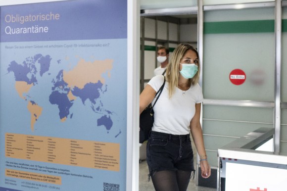Una ragazza con mascherina in volto all uscita dall aeroporto di Zurigo.