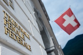 muro di un edificio con bandiera svizzera e scritta tribunale penale federale