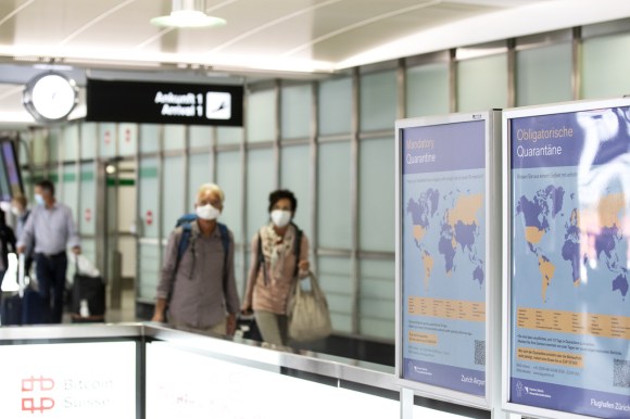 Cartelli con cartina del mondo, alcuni paesi evidenziati e scritta quarantena obbligatoria in ambiente aeroportuale