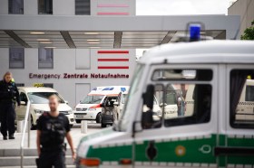 Entrata di un edificio ospedaliero con agenti di polizia e un ambulanza parcheggiata