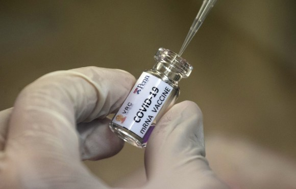 Una siringa prelevano da una fialetta un vaccino.