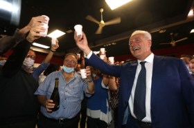 il candidato del centrosinistra Eugenio Giani attorniato da altre persone brinda