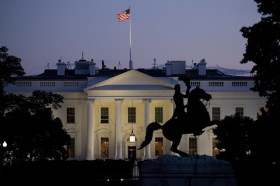 La Casa Bianca in un immagine notturna con in alto la bandiera americana.