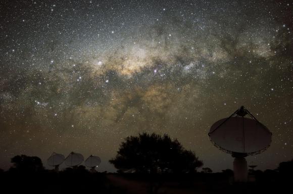 Radiotelescopio fotografato di notte; sopra di esso si vede nitida la volta celeste