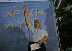 Nikos Michaloliakos mentre con il braccio alzato fa il saluto fascista.