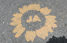 Un sole e al centro la scritta JA (sì) dipinto sull asfalto