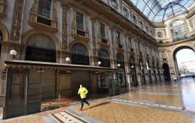Una persona fa jogging in una galleria Vittorio Emanuele completamente vuota e chiusa.