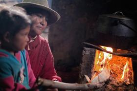 una donna e una bambina peruviana di fronte a un forso a legna