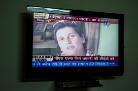 Il volto di Karin Scheidegger appare su una TV con sottopancia Breaking news e scritte in hindi