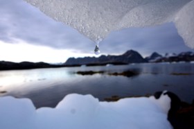 Panorama artico con blocchi di ghiaccio che fluttuano sull acqua e, in primo piano, goccia di iceberg in scioglimento
