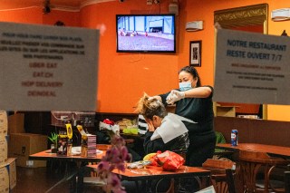 una donna taglia i capelli a un altra donna all interno di un ristorante