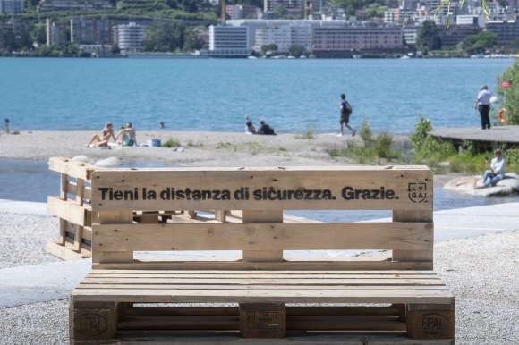 Su una panchina in riva al lago di Lugano si legge l invito a tenere le distanze di sicurezza.