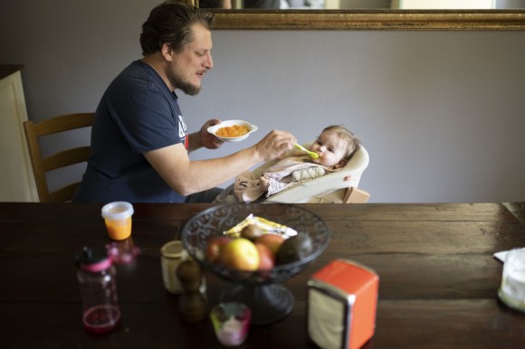 Un uomo mentre da da mangiare a un neonato