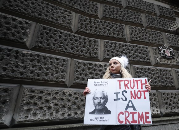 Manifestante con cartello che chiede la liberazione di Assange.