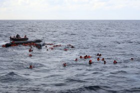 profughi in mare in attesa dei soccorsi