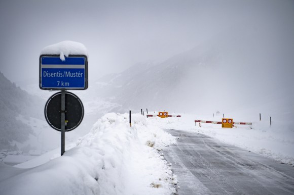 Strada di montagna da cui la neve è stata rimossa solo fino a una sbarra con segnale di divieto