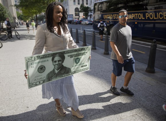La rappresentante del Massachusetts Ayanna Pressley con in mano una gigantografia della banconota da 20 dollari