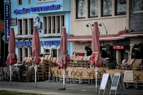 Vista trasversale di alcuni locali tedeschi (lo si desume dalle scritte) con serrande giù, ombrelloni chiusi e sedie accatastate