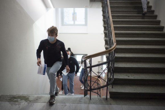 Ragazzi che salgono le scale di una scuola per fare il test.