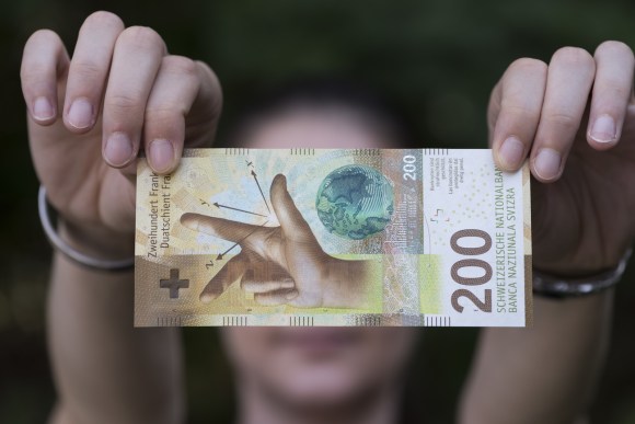 due mani tengono una banconota da 200 franchi