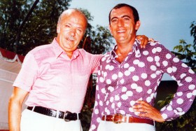 Due uomini in maniche di camicia con colori accesi sorridono alla camera