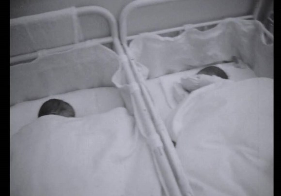 Immagine b/n di due culle d ospedale occupate da neonati