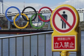 I cinque anelli del logo olimpico appesi a Tokyo vicino al fiume.