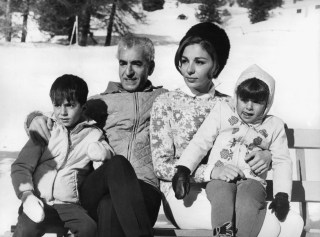 uomo e donna con due bambini seduti su una panchina