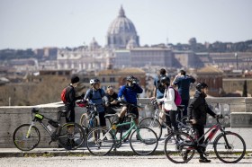 Ciclisti a Roma con sullo sfondo la basilica di San Pietro.