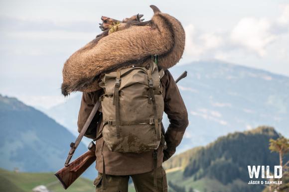 cacciatore con un cervo sulle spalle