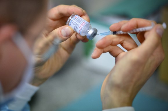 Un operatore sanitario riempie una siringa con il vaccino Moderna.