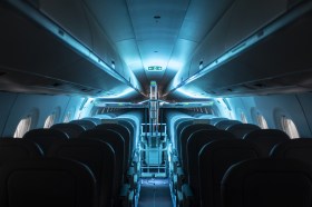 L interno di un aereo vuoto con le luci spente.
